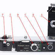 【NIKON(尼康)】尼康  F2 photomic S拆解图， 尼康F2推出的同时一款新设计的卷片马达MD-1也同时面世，到了1972年改良为MD-2和MD-3，最高速度可达到每秒5张。A为相机后盖开启扳手的安置仓，B为马达计数器清零按钮，C为胶片回转顶杆，D为调速盘，E为回片马达启动钮，F为相机后盖开启扳手。
